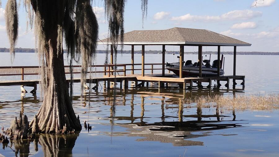 A wooden boat dock at the rear of a Florida waterfront lot