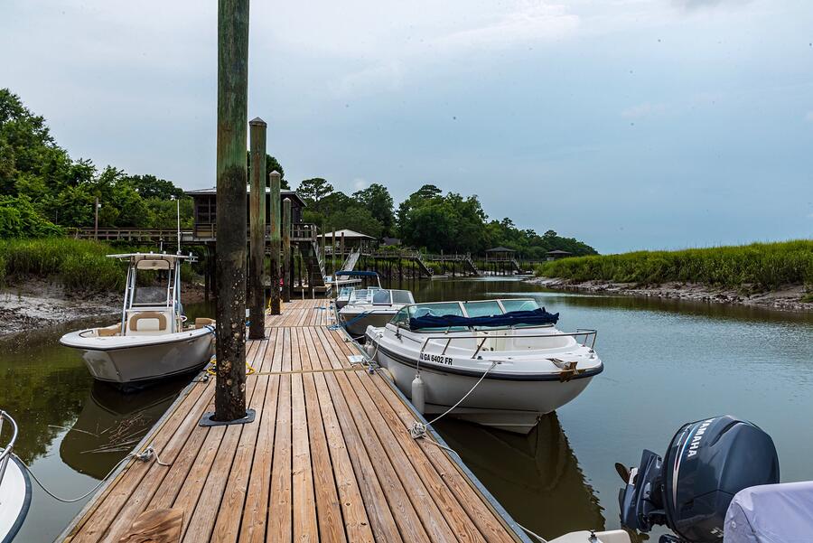 Boats tied up at a wooden pier in a green, sheltered harbor