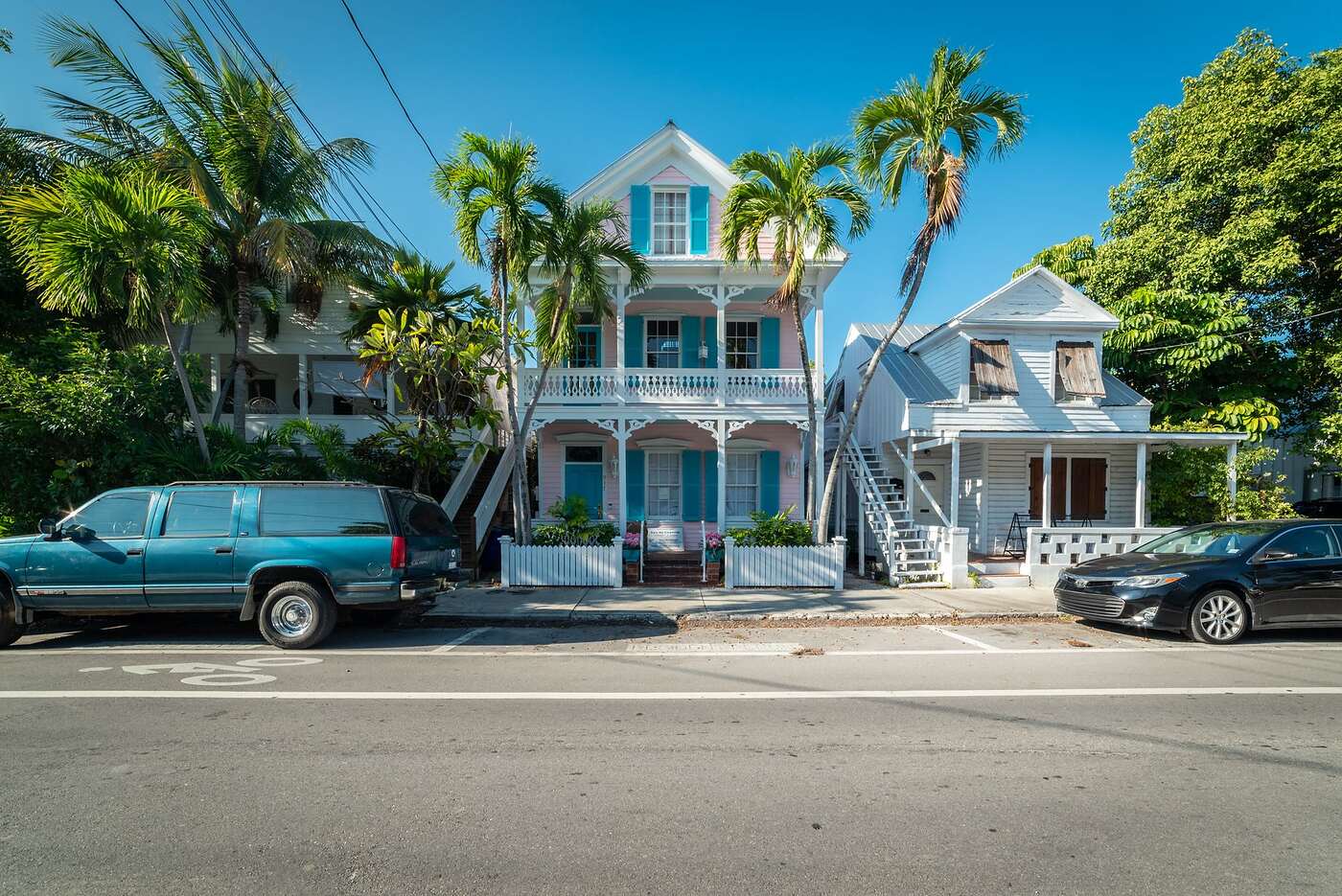 Historic wood-frame houses with porches and palms on an older Florida street
