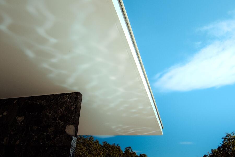 The underside of a white roof overhang and soffit line seen from below during an inspection