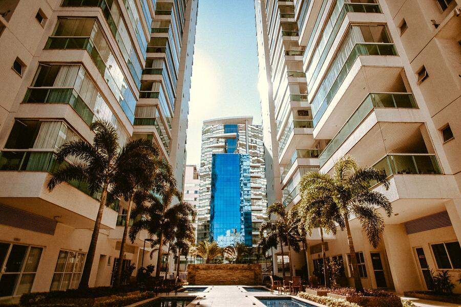 A condo tower with palms in front of it