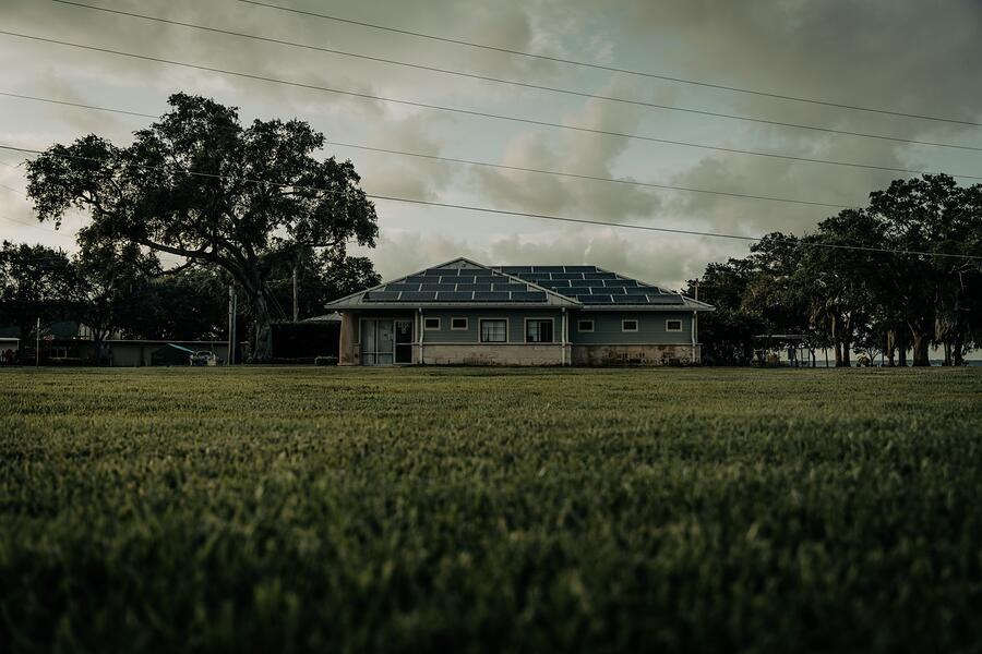 A single-story ranch house on a large lot with mature trees