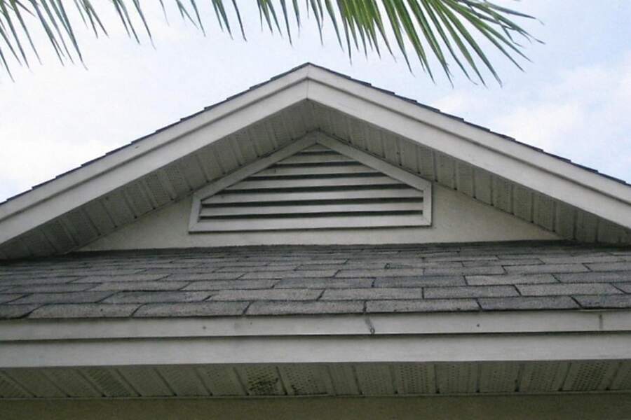 A shingle roofline with a gable vent
